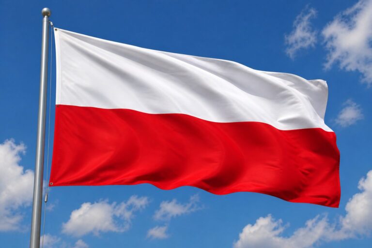 Flaga Polski powiewająca na wietrze na tle błękitnego nieba z białymi chmurami, biało-czerwone barwy narodowe